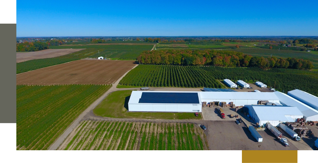 A large farm with solar panels on a barn.
